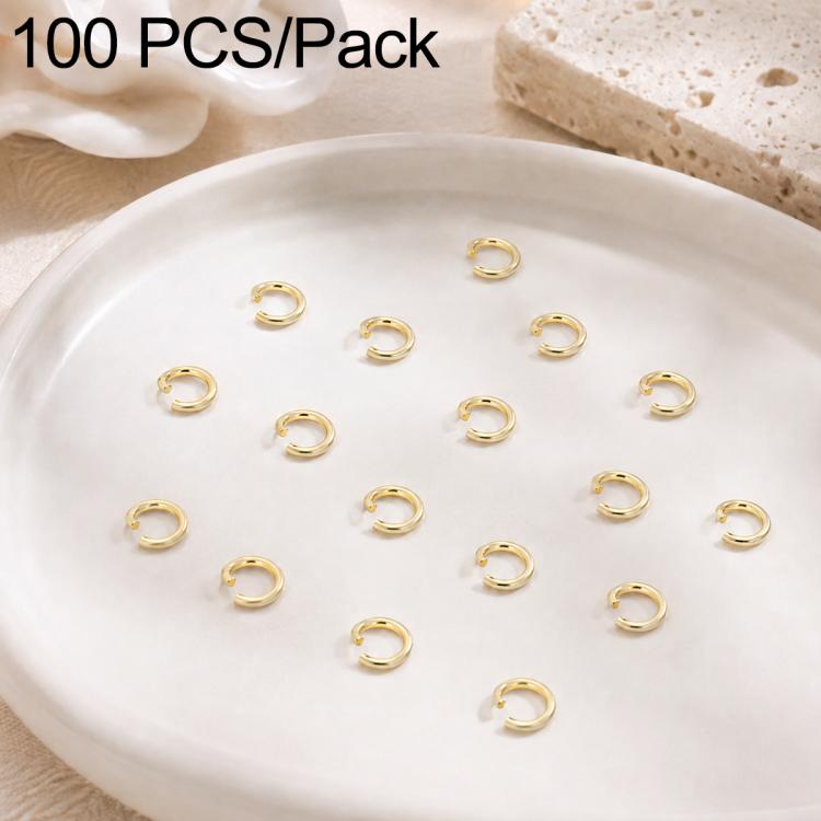 Gold open jump rings, small split loops scattered across a round dish