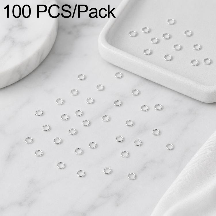 Silver open jump rings, 100-piece set scattered across a marble surface for crafts