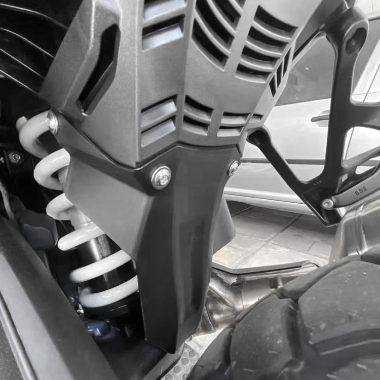 Installed motorcycle rear hugger wheel fender, black guard mounted near rear suspension