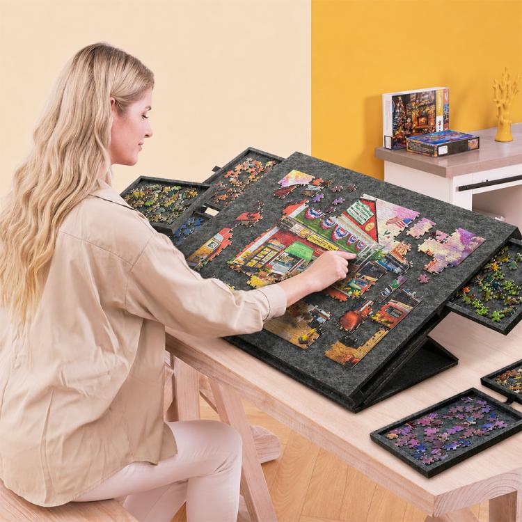 Grey felt puzzle sorting board on table with colorful center artwork and drawer storage panels