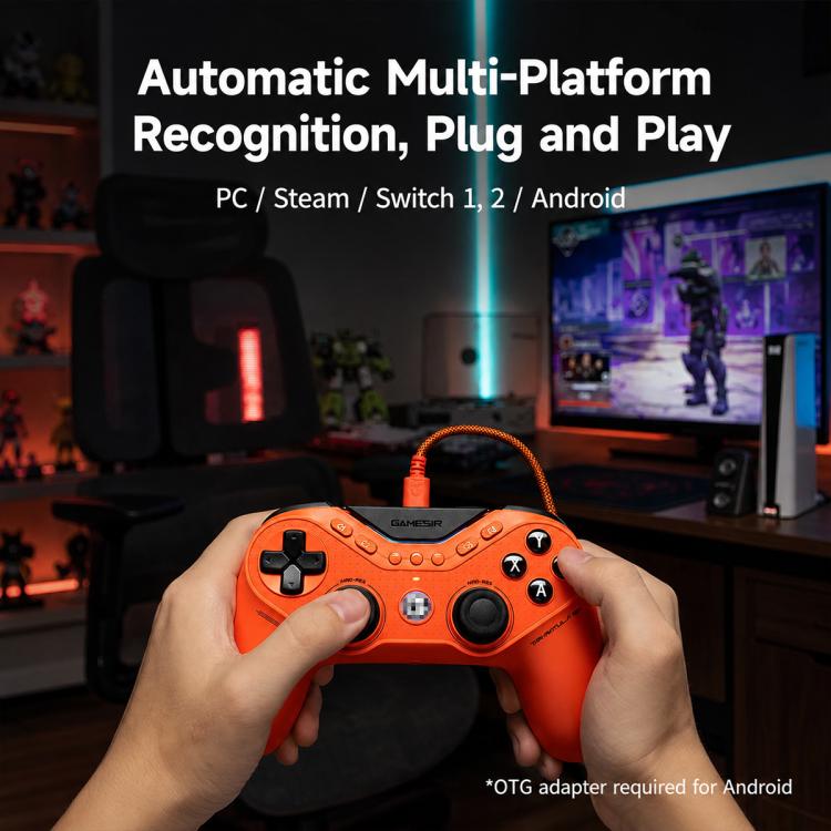 Orange wired game controller held by hands, showing ABXY buttons and thumbsticks