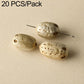 Light cream speckled round seed beads with drilled holes on a pin for DIY bracelets