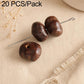 Dark brown round seed beads with through holes on metal pins.