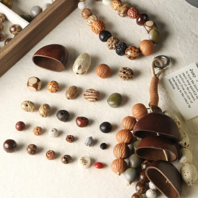 Seed bead mix display with clustered coconut shell bell charm and small spacer beads