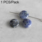 Round blue speckled stone beads on wire pin, polished surface