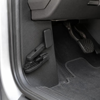 Black hood release handle lever on car door panel trim