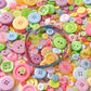Close-up of mixed pastel round resin buttons with a colorful wire bundle