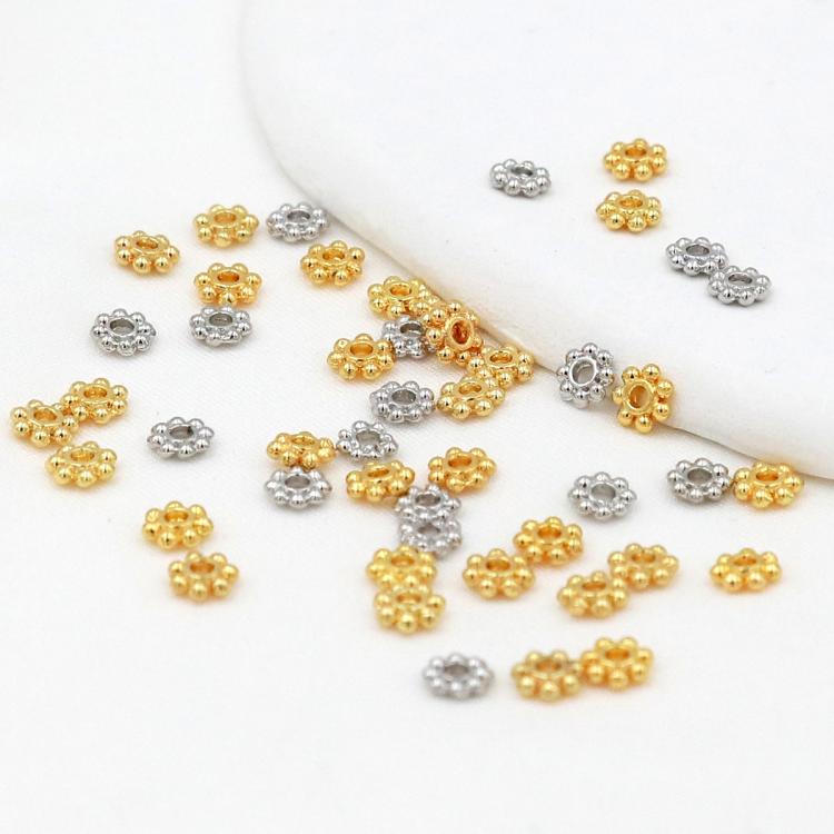 Gold and silver snowflake bead cap spacers scattered, flower-like heads with center holes