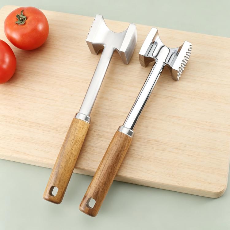 Double-sided meat mallet with stainless tenderizing faces and wooden handles on a board