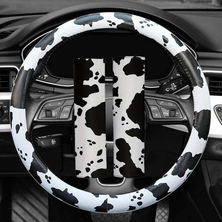 Cow print steering wheel cover with black-and-white pattern over the wheel rim