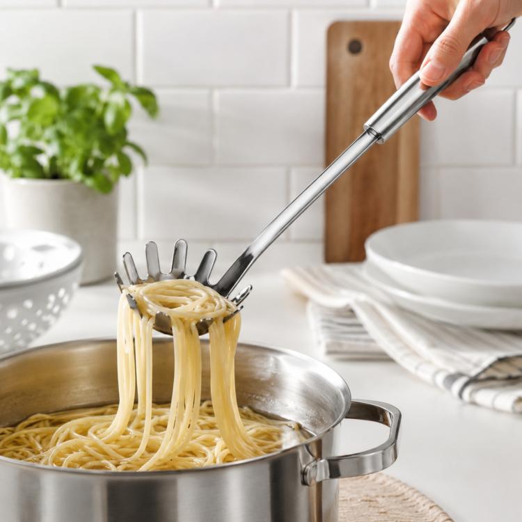 Stainless steel pasta server with fork tines for lifting spaghetti from a pot