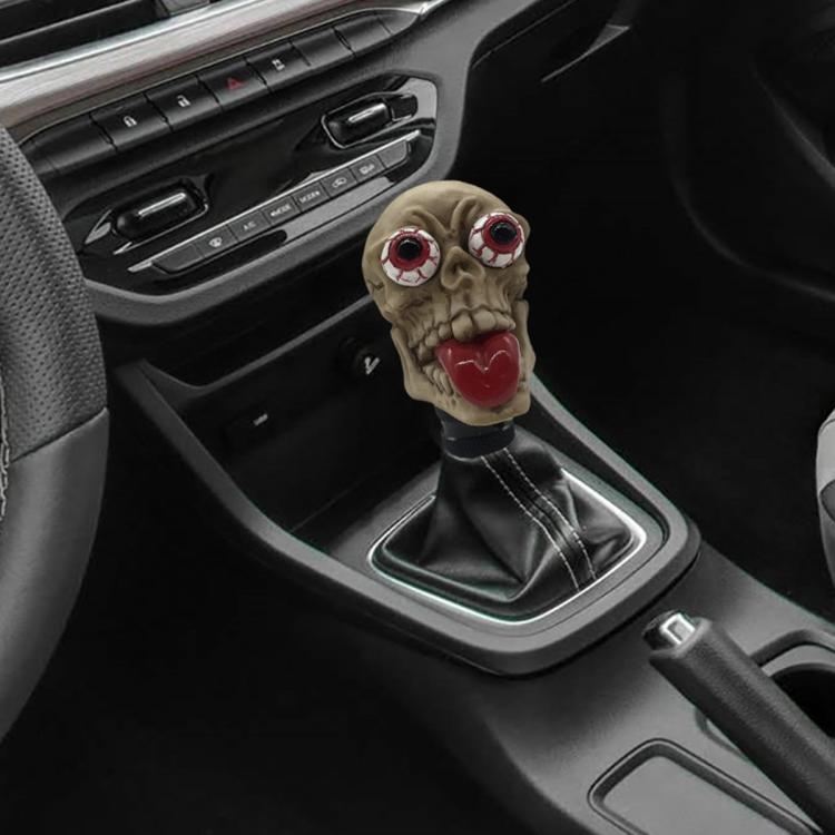 Beige skull-style manual gear shift knob with red eyes and red tongue
