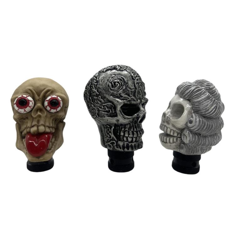Set of skull-style manual gear shift knobs: beige, black, and gray