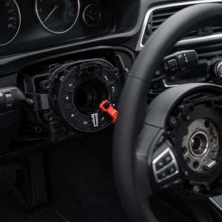 Steering wheel clock spring airbag cable assembly with orange release tab, shown opened
