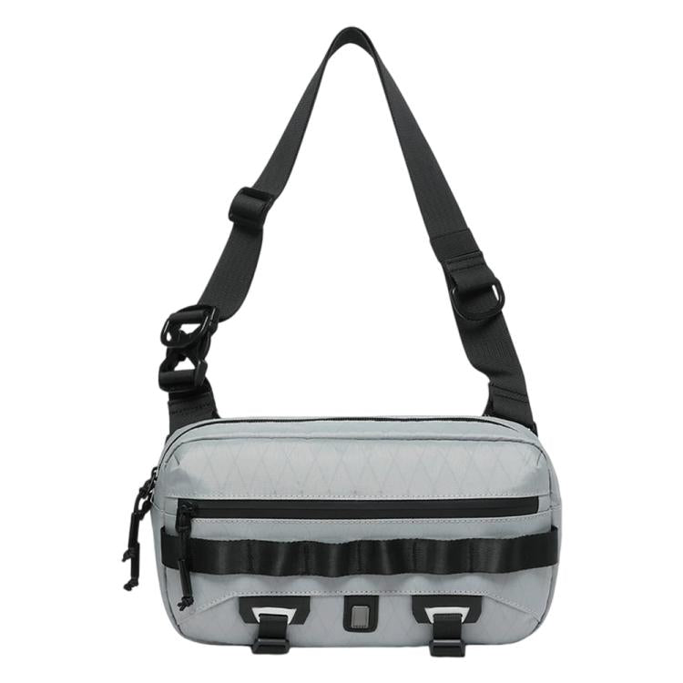 Grey crossbody sling bag with padded shoulder strap and front utility strap details.
