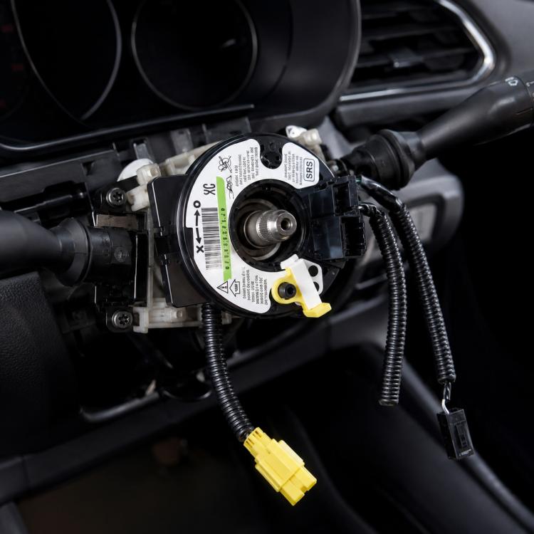 Clock spring spiral cable assembly with yellow airbag connectors, mounted in steering column