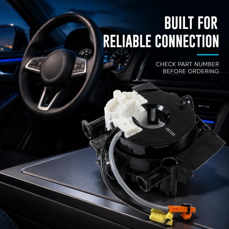 Clock spring spiral cable assembly with black housing and white connector near steering column