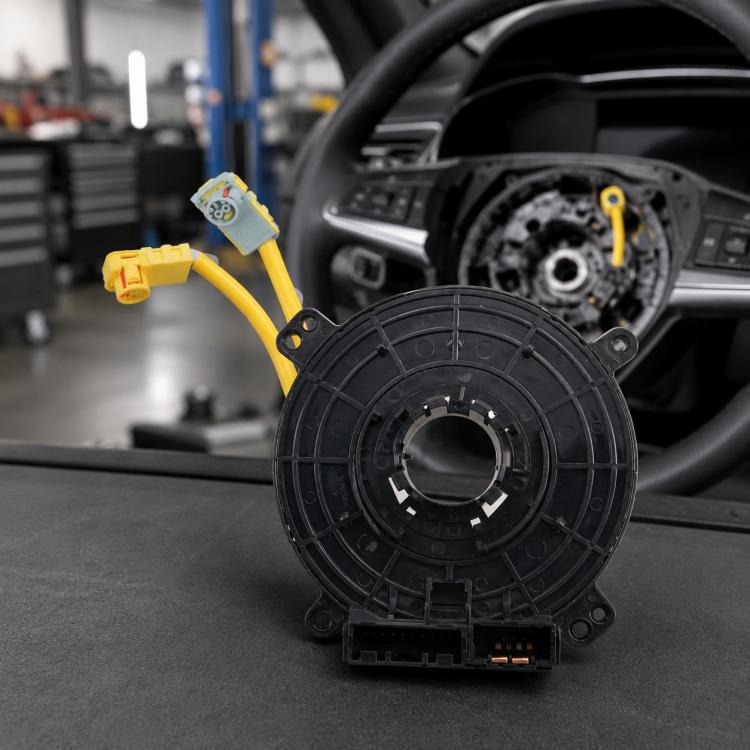 Black steering wheel clock spring with yellow wiring harness and multi-pin connector