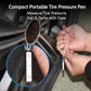 Hand holding a tire pressure gauge pen to the tire valve to measure pressure.