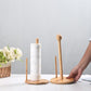 Bamboo paper roll holder set with white roll on round bases, hands placing papers