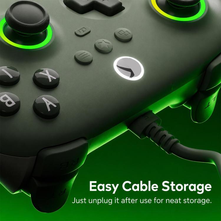 Close-up of dark wired controller with green glowing ring and connected cable