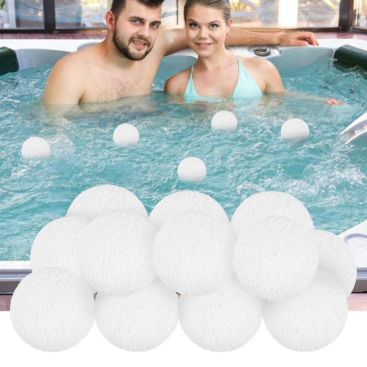 Four white sponge filter balls floating in hot tub water