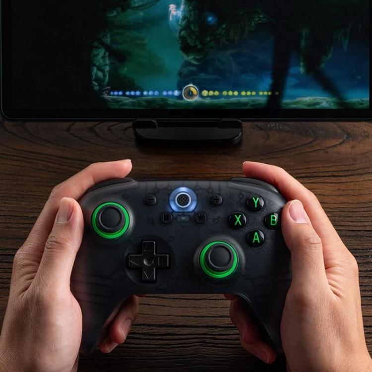 8BitDo Orion Youth wireless controller held in hands with green controls