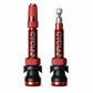 Pair of red Presta tubeless valve extenders with aluminum stems and rubber bases