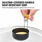 Yellow silicone-covered handle grips a black egg poacher over a boiling pot