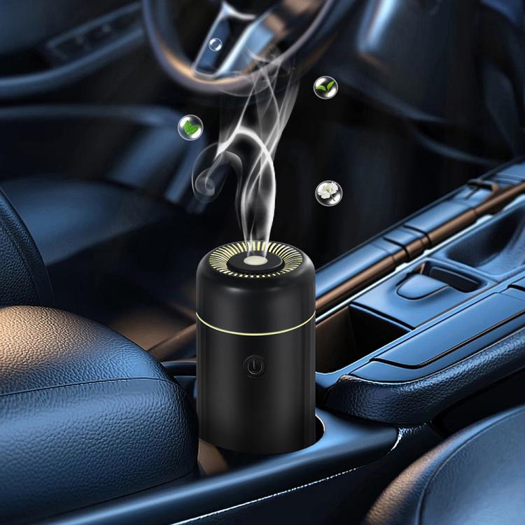 Black mini car humidifier and air freshener on console with mist rising from top vent