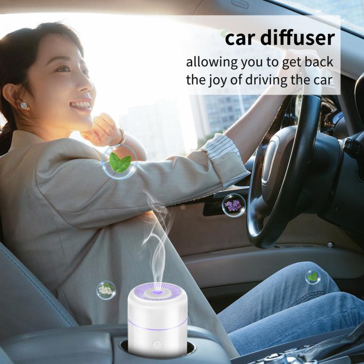 White mini car humidifier and air freshener in vehicle with glowing top mist vent