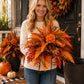 Orange-red fall floral garden stake arrangement held with fern leaves and berry accents