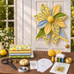 Quilted bow wall decor with yellow, blue, and green floral star petals and round center