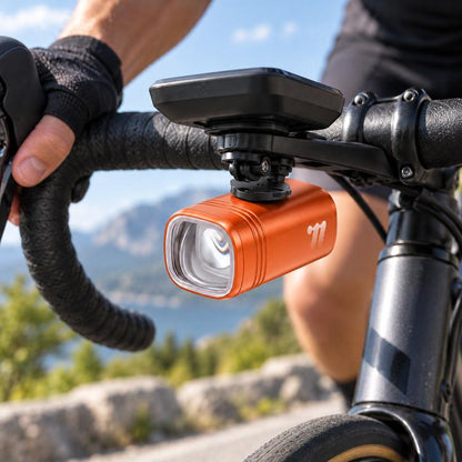 Orange bike headlight with front mount bracket and clear LED lens on handlebar