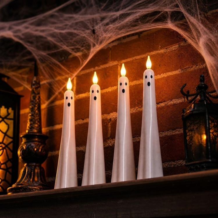 White ghost-shaped LED flameless candles with glowing tips and black face details