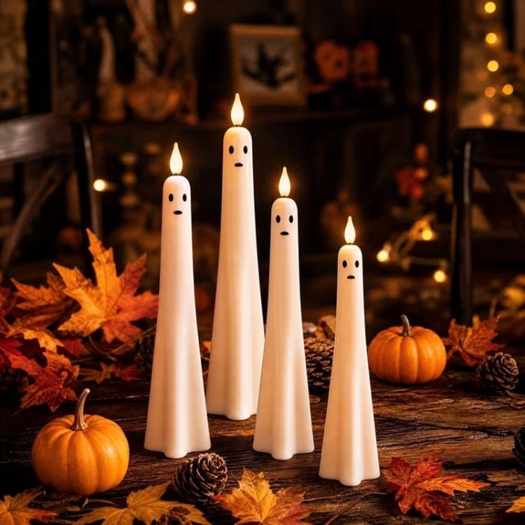 Ghost-shaped LED flameless candles in white with black facial marks and glowing tips