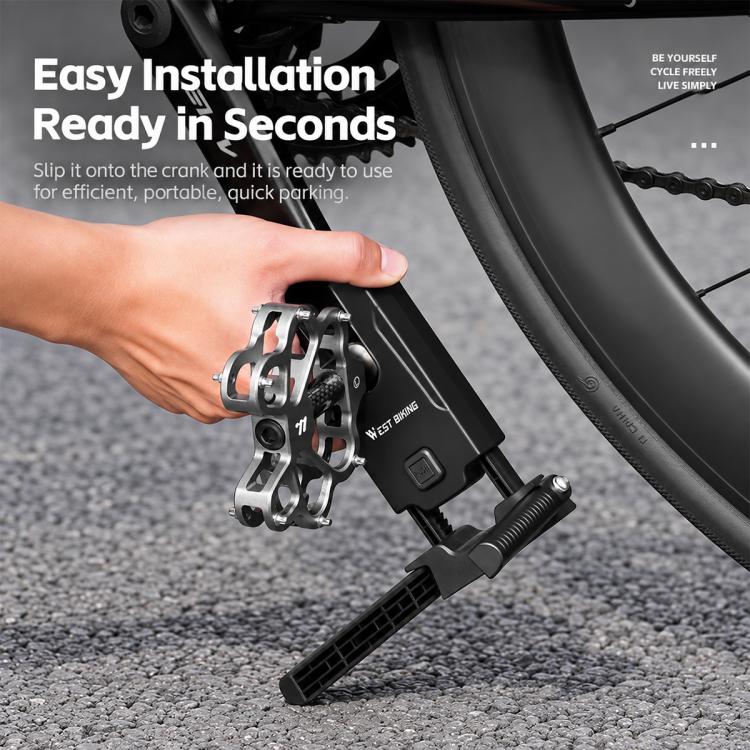 Hand mounting a black crank kickstand onto the bike crank arm