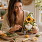 3D fabric poke gnome with yellow sunflowers and white beard, held by woman