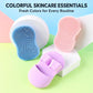 Colorful silicone face cleansing brushes in blue, pink, and purple with finger-grip backs