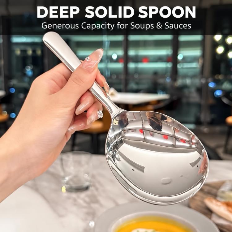 Stainless steel round soup spoon held in hand with reflective bowl