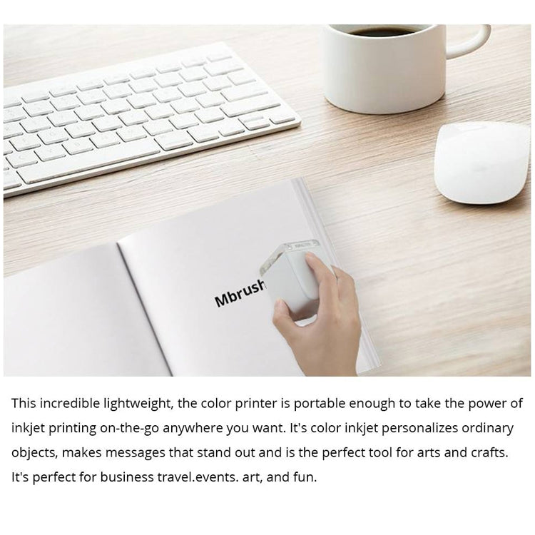 Mini portable color ink printer held near white paper on desk