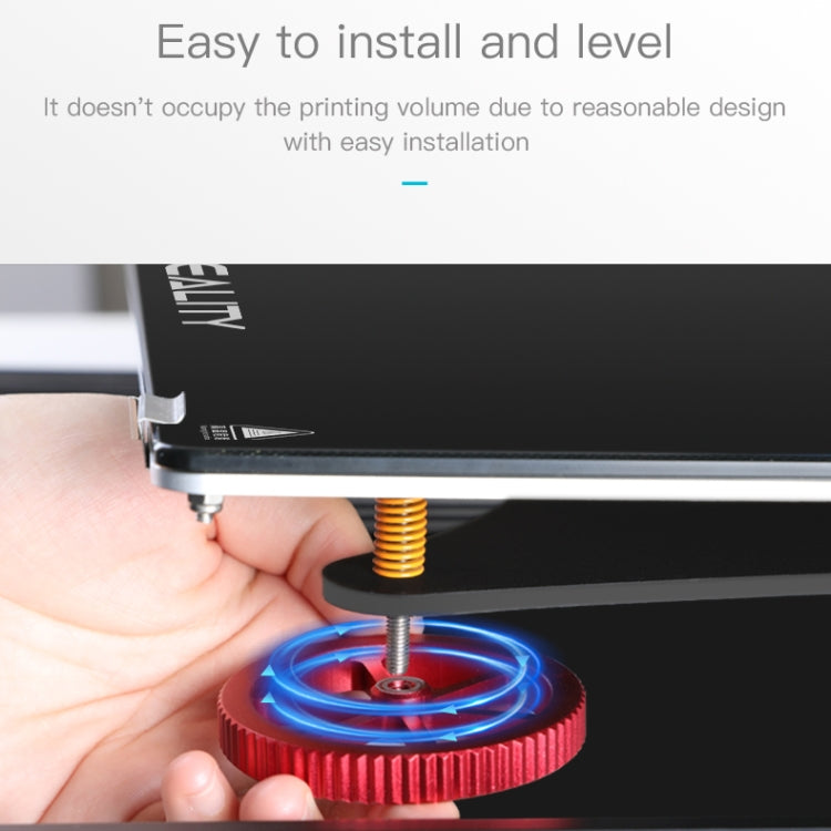Hand holding a red metal leveling nut while adjusting the threaded screw on printer bed