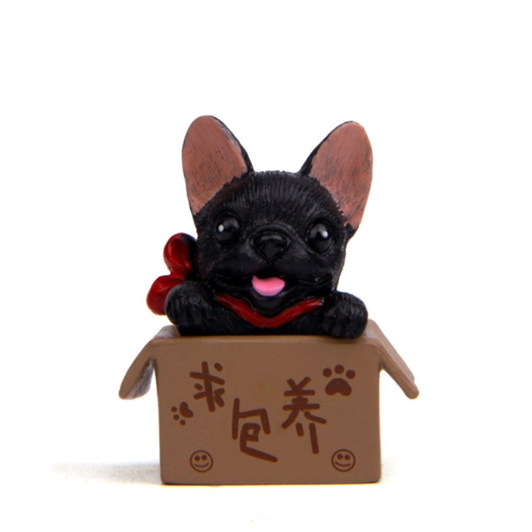 Black bulldog doll in a brown cardboard box with paw and character prints