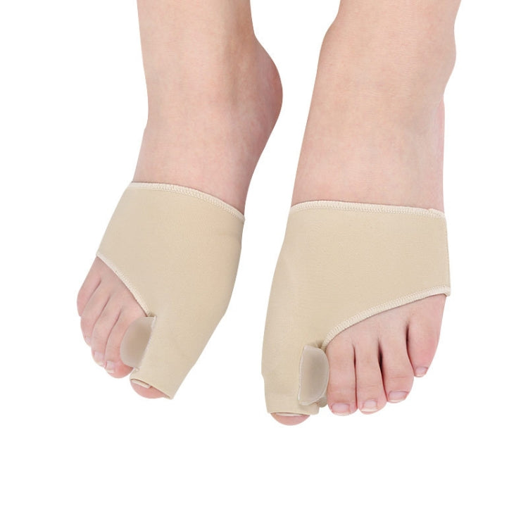 Pair of beige toe correction sleeves on feet with cushioned toe separator pads