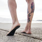 Black anti-slip sandal insole under foot, dotted grip texture for beach wear
