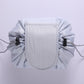 Light gray ruffled drawstring cosmetic pouch with stitched front panel and side drawstrings