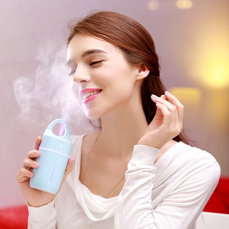 Mini portable USB humidifier, white with blue LED light, releasing visible mist