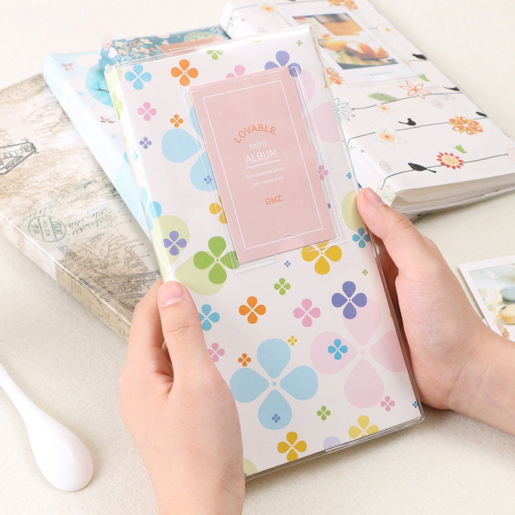 Mini photo album with four-leaf clover pattern cover, pastel blossoms and geometric shapes.