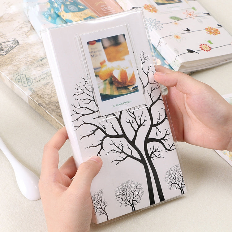 Mini photo album with black tree silhouette cover, open photo pocket page and card insert.
