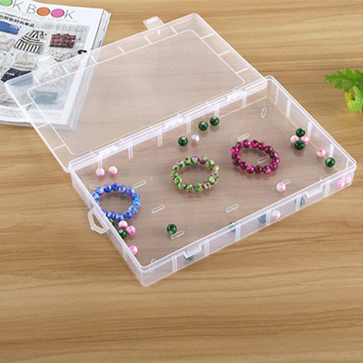 Clear plastic jewelry storage box with removable grid compartments and small beads inside
